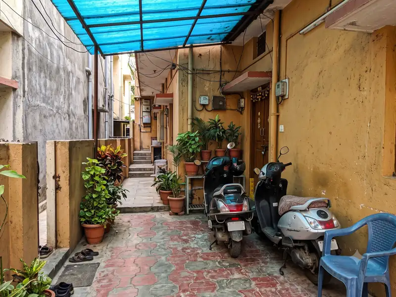 Scooters parked in a covered courtyard with potted plants